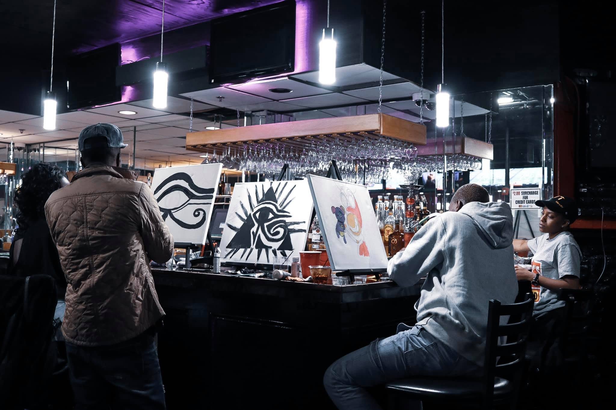 Guests and canvases gathered around the bar during the painting event