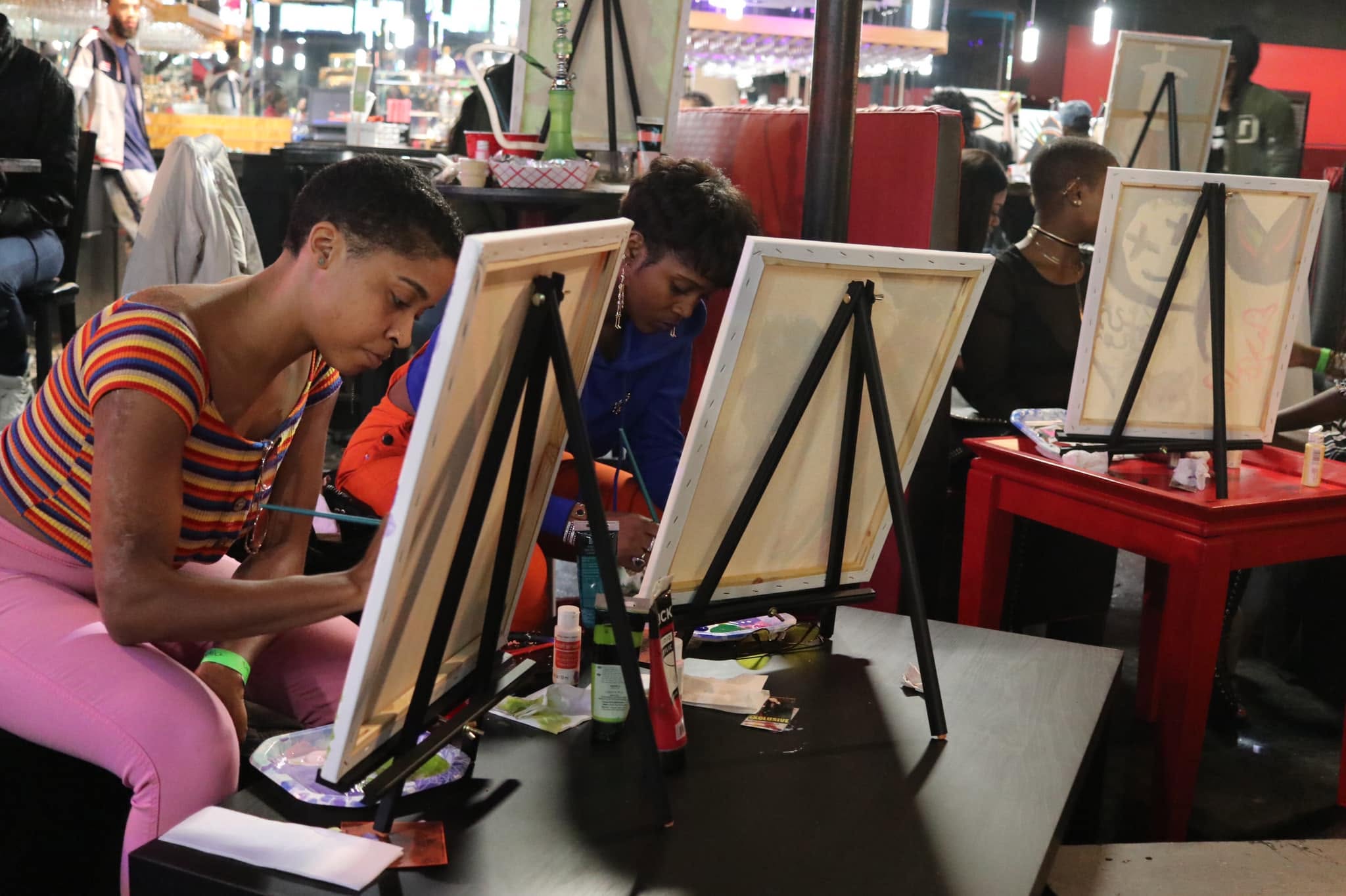 Guests painting at tabletop easels during Backwoods and Brushes